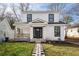Charming two-story home with white siding, black framed windows, a front porch, and a stone walkway at 1449 Athens Sw Ave, Atlanta, GA 30310