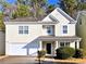 Two-story house with light beige siding, a double garage, and manicured landscaping at 4534 Parkway Cir, Atlanta, GA 30349