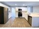 Modern kitchen with white cabinets, stainless steel appliances, and wood-look flooring at 4534 Parkway Cir, Atlanta, GA 30349