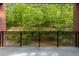 View of the outdoors from the balcony with black metal railing and brick accents at 3280 Stillhouse Se Ln # 305, Atlanta, GA 30339