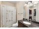 This bathroom features a dark granite countertop with a single sink and decorative shower curtains at 3280 Stillhouse Se Ln # 305, Atlanta, GA 30339