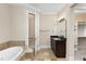 Bathroom featuring a soaking tub and granite countertops, leading to a walk-in closet at 3280 Stillhouse Se Ln # 305, Atlanta, GA 30339