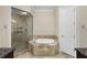 Bathroom featuring a shower with glass door, jetted tub and granite countertops at 3280 Stillhouse Se Ln # 305, Atlanta, GA 30339