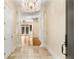 Bright foyer with tiled floor, chandelier, and white columns leading to the living areas beyond at 3280 Stillhouse Se Ln # 305, Atlanta, GA 30339