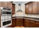 Close-up of the modern kitchen with stainless steel appliances, dark wood cabinets and stone countertops at 3280 Stillhouse Se Ln # 305, Atlanta, GA 30339
