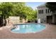 Outdoor pool surrounded by lush landscaping, brick patio, and a stone clubhouse at 3280 Stillhouse Se Ln # 305, Atlanta, GA 30339