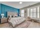 Main bedroom with a large bed, blue accent wall, and bay window at 1072 Brookglynn Trce, Decatur, GA 30032