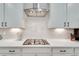 Close up of modern stovetop with subway tile backsplash and white cabinets at 1072 Brookglynn Trce, Decatur, GA 30032