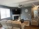 Cozy living room boasts a fireplace, ceiling fan, neutral color palette, and a plush leather sofa set at 11547 Hathaway Dr, Hampton, GA 30228
