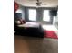 Spacious main bedroom featuring a large bed, ceiling fan, and natural light from two windows at 11547 Hathaway Dr, Hampton, GA 30228