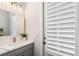 Well-lit bathroom featuring a vanity with modern fixtures, a stylish mirror, and a window with shutters at 396 Silverbell Way, Marietta, GA 30060