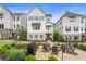 Stunning two-story townhouse featuring a brick patio with an outdoor fire pit and chairs, complemented by landscaped grounds at 396 Silverbell Way, Marietta, GA 30060