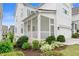 View of a screened porch with white railings, adjacent to a garage and surrounded by greenery and flowers at 396 Silverbell Way, Marietta, GA 30060