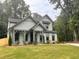 Two-story farmhouse features a welcoming front porch and manicured lawn at 1679 Eastside Parc St, Atlanta, GA 30316