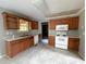 Kitchen with wood cabinets, white appliances, and tile floors at 166 Greentree Trl, Temple, GA 30179