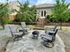Relaxing backyard patio with stone seating area, fire pit, and mature trees at 3909 Makeover Ct, Atlanta, GA 30349