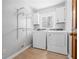 Functional laundry room with modern washer and dryer, white cabinets, and shelving for organized storage at 239 Cedar Ridge Dr, Dallas, GA 30157