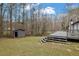 View of the backyard featuring a wooden deck, storage shed, and grassy lawn at 3178 Berrong Way, Stone Mountain, GA 30087