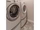 Modern laundry room featuring a front load washer and dryer set with gray stone flooring at 4480 Sunflower Cir, Cumming, GA 30040