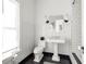 Bathroom with white subway tile, pedestal sink, and toilet at 9057 Selborne Ln, Chattahoochee Hills, GA 30268