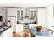 White kitchen with stainless steel appliances and farmhouse table at 9057 Selborne Ln, Chattahoochee Hills, GA 30268
