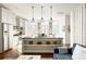 Modern white kitchen with island and stainless steel appliances at 9057 Selborne Ln, Chattahoochee Hills, GA 30268