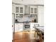 White kitchen with stainless steel appliances and hardwood floors at 9057 Selborne Ln, Chattahoochee Hills, GA 30268