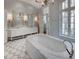 Bright bathroom featuring marble counters, patterned tile floor, and a luxurious soaking tub with polished nickel fixtures at 133 Blackland Nw Rd, Atlanta, GA 30342