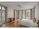 Sunlit bedroom with hardwood floors, desk, and large windows adorned with patterned curtains, offering an airy feel at 133 Blackland Nw Rd, Atlanta, GA 30342