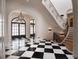 Stunning foyer features black and white marble floors, grand staircase, arched doorways and elegant chandelier at 133 Blackland Nw Rd, Atlanta, GA 30342