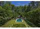 Aerial view of a stunning backyard with a swimming pool, meticulously manicured lawn, and lush landscaping at 133 Blackland Nw Rd, Atlanta, GA 30342