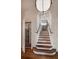 Elegant staircase with wood treads and wrought iron railing, complemented by white trim and modern lighting fixture at 133 Blackland Nw Rd, Atlanta, GA 30342