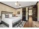 Spacious bedroom with a rattan bed frame and a view into the kitchen at 2575 Peachtree Ne Rd # 9G, Atlanta, GA 30305