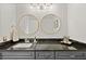 Bathroom with dark granite countertop, double vanity, and gold framed mirrors at 16 Ivy Ne Rdg, Atlanta, GA 30342