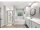 Modern bathroom featuring a walk-in shower, soaking tub, double vanity, and hexagon mirror at 319 Pinewood Dr, Woodstock, GA 30189