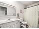 Clean bathroom featuring a white vanity and framed mirror with neutral shower curtain at 319 Pinewood Dr, Woodstock, GA 30189