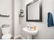 Charming powder room featuring a pedestal sink, framed mirror, and stylish decor at 319 Pinewood Dr, Woodstock, GA 30189