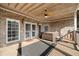 Relaxing back porch with a hot tub, brick columns, ceiling fan, and wood paneled ceiling at 19 Spring Lake Trl, White, GA 30184