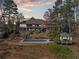 Expansive backyard featuring a covered pool, gazebo, multi-tiered deck and mature trees at 19 Spring Lake Trl, White, GA 30184
