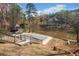 A serene backyard featuring a covered pool, gazebo, and a tranquil lake at 19 Spring Lake Trl, White, GA 30184