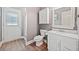 Neutral bathroom features an enclosed shower, white toilet and white vanity with ample natural light at 19 Spring Lake Trl, White, GA 30184