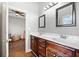 Bright bathroom with double sink vanity, dark wood cabinets, and views into the bedroom at 19 Spring Lake Ne Trl, White, GA 30184