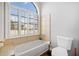Bright bathroom with a large window over the tub and neutral tiled walls at 19 Spring Lake Trl, White, GA 30184