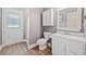Bright bathroom featuring white cabinetry, a walk-in shower, and door to exterior at 19 Spring Lake Trl, White, GA 30184