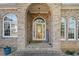Inviting brick entrance with decorative glass door and manicured plants at 19 Spring Lake Trl, White, GA 30184