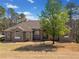Brick home with a meticulously maintained lawn and mature tree, showcasing classic design and curb appeal at 19 Spring Lake Trl, White, GA 30184