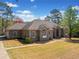Well-manicured lawn and brick house, highlighting its stately presence and attention to landscape detail at 19 Spring Lake Trl, White, GA 30184