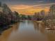 Scenic lake view showcasing a tranquil setting with vibrant sunset colors and wooded surroundings at 19 Spring Lake Trl, White, GA 30184