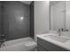 Modern bathroom featuring gray tiled walls and a sleek, white vanity and toilet at 1980 Flying Scotsman Dr # 10, Kennesaw, GA 30144