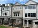 View of new townhomes with brick and siding, featuring multiple windows, and black metal fence at 1980 Flying Scotsman Dr # 10, Kennesaw, GA 30144